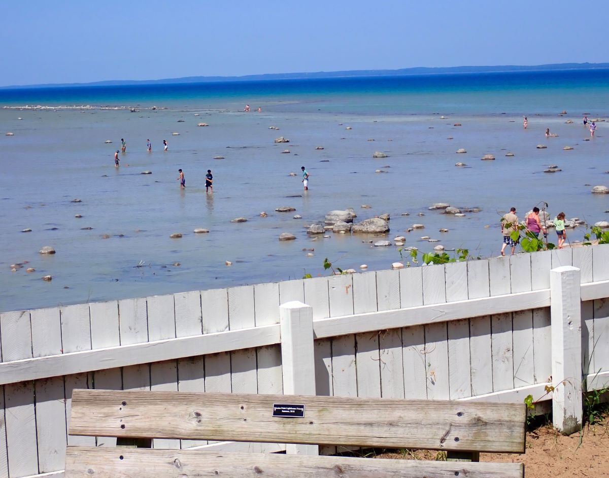 People enjoying the beach in front of the Mission Point Lighthouse.