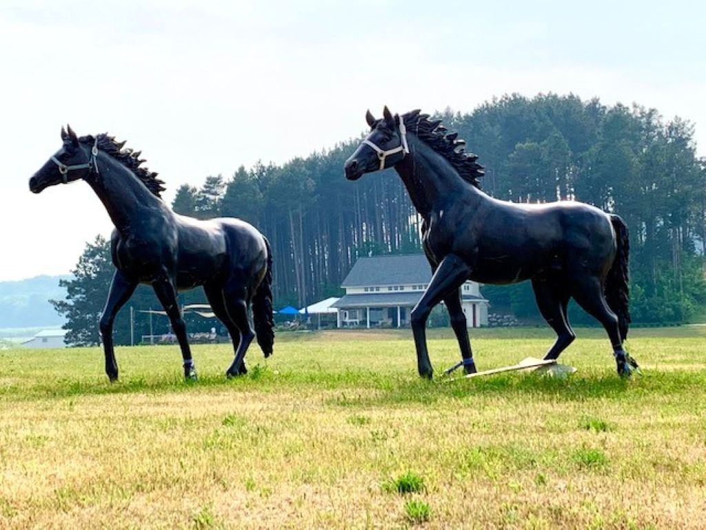 Horse statues at 2K Farms Ciders & Winery, with the tasting room in the background.
